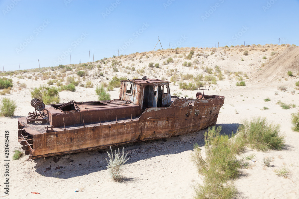 Rustic boats on a ship graveyards on a desert around Moynaq, Muynak or Moynoq - Aral sea or Aral lake - Uzbekistan in Central Asia