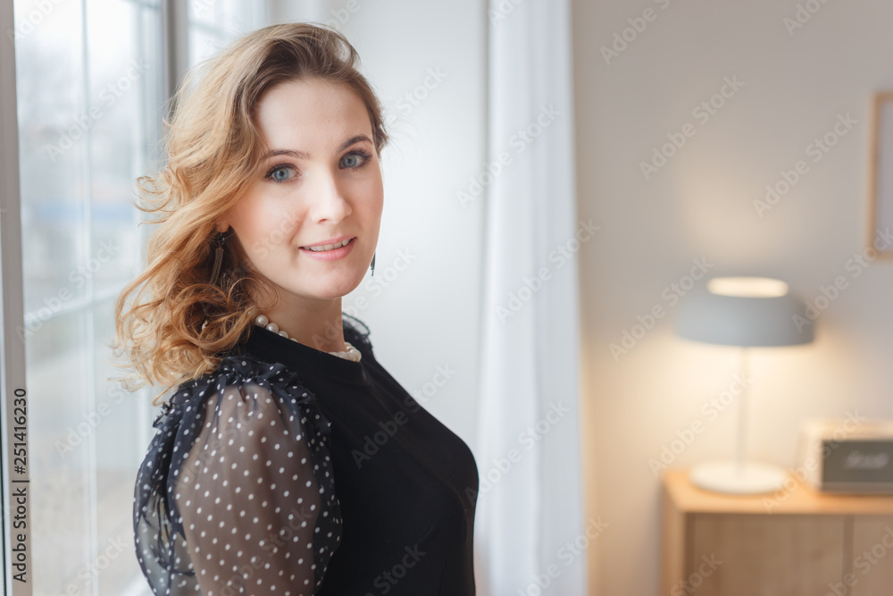 Portrait of beautiful young blonde woman in black dress Portrait of beautiful young blonde woman in black dress