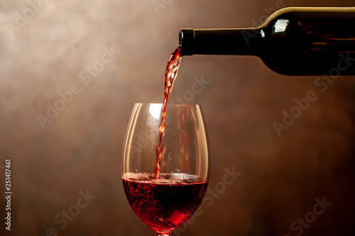 Pouring red wine into a glass, close-up