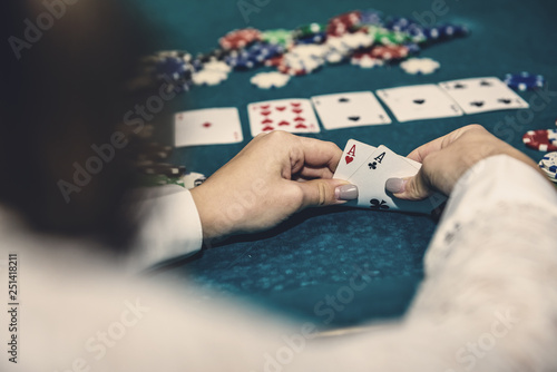 Poker chips and female hands holding playing cards
