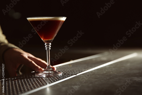Barman serving espresso martini cocktail at counter, closeup. Space for text