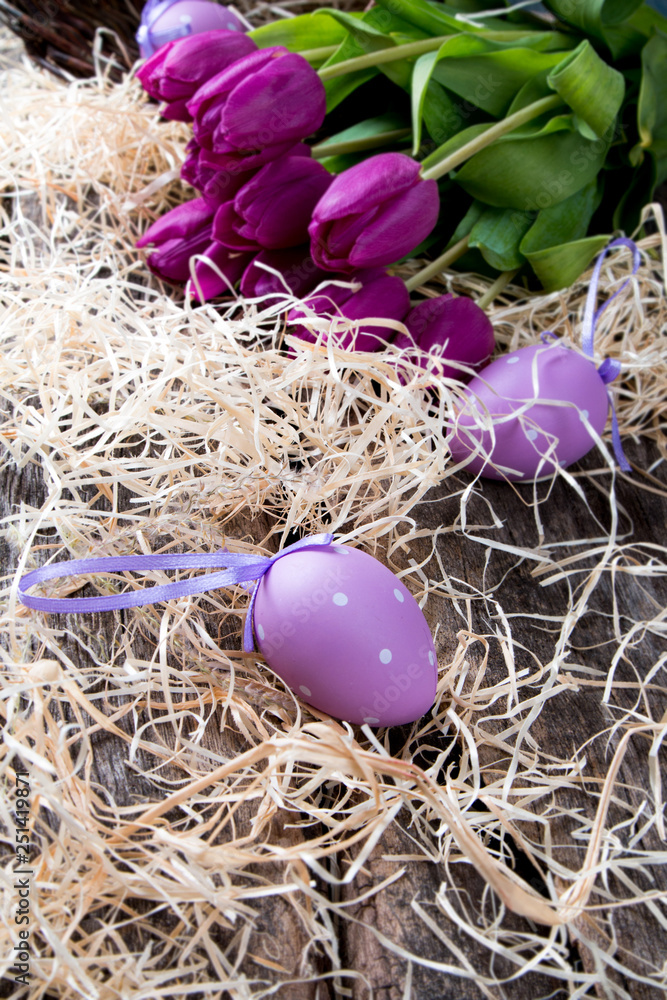 Easter eggs and flower on wooden table. Spring concept on plank.