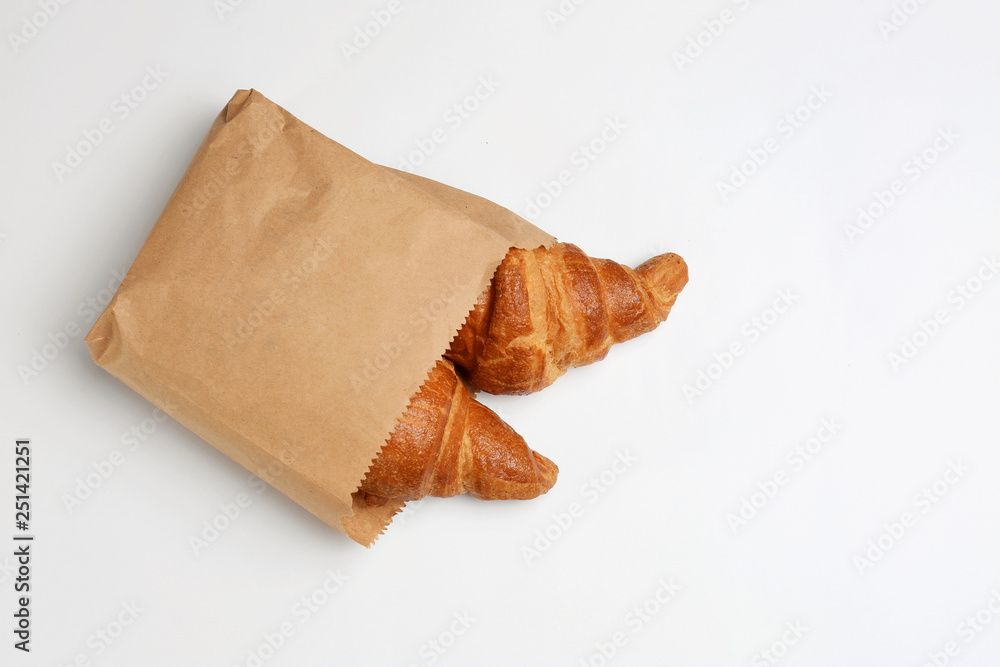 Paper bag with croissants on white background, top view. Space for ...