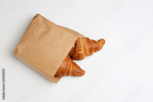 Paper bag with croissants on white background  top view. Space for design