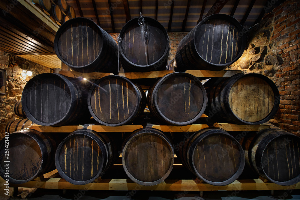 Rows of alcoholic drums in stock. Distillery. Cognac, whiskey, wine, brandy. Alcohol in barrels