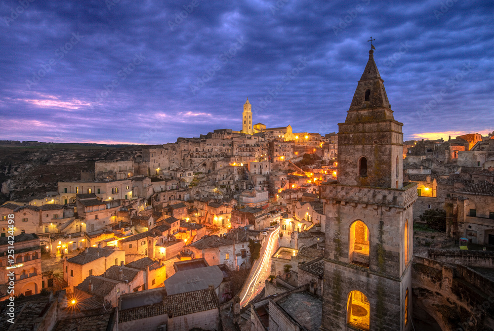 Matera, Basilicata, Italy, landscape at dawn after sunset of the old town (sassi di Matera), European Capital of Culture. Church San Pietro Barisano and duomo cathedral. Unseco World Heritage site