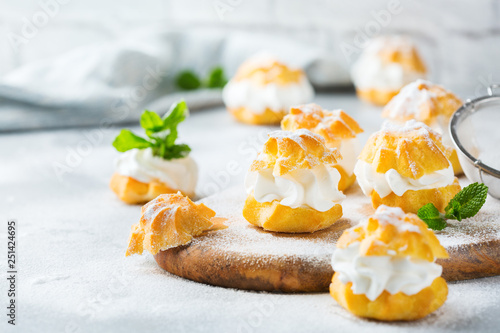 Foto Delicious sweet profiteroles with cream on a modern kitchen table