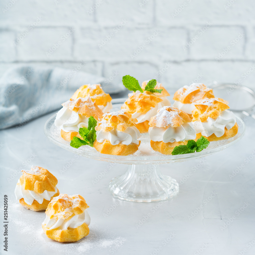 Delicious sweet profiteroles with cream on a modern kitchen table Delicious sweet profiteroles with cream on a modern kitchen table