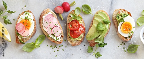 Fotografia Breakfast sandwich bread with avocado, egg, radishes and tomatoes