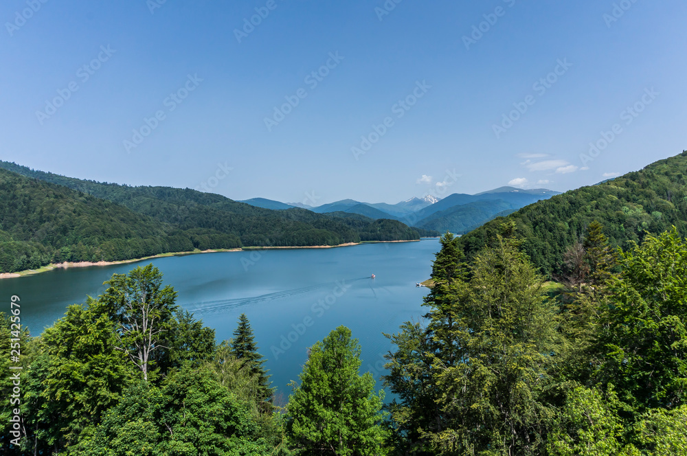 Obraz premium Fantastic panorama of mountain lake with overcast sky of Vidraru Lake. Vidraru Dam, Romania. Carpathian Mountains, Fagaras ridge