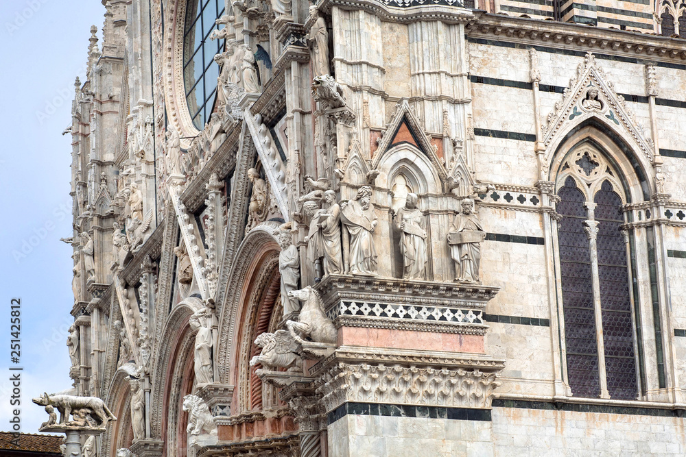 Facade with sculptures, historical Italian architecture of the 14th century, Duomo di Siena with reliefs, Tuscany. UNESCO World Heritage Site