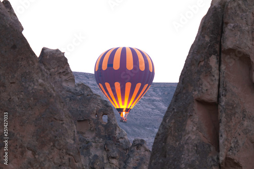 Many colorful hot air balloons flight above mountains - panorama of Cappadocia at sunrise. Wide landscape of Goreme valley in Cappadocia