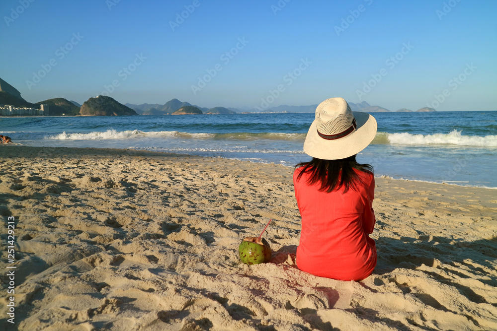 Woman relaxing on the sunny Copacabana beach in Rio de Janeiro, Brazil, South America