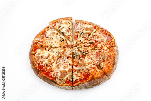 cut Pizza close up with cheese ham and tomato on a white stone background