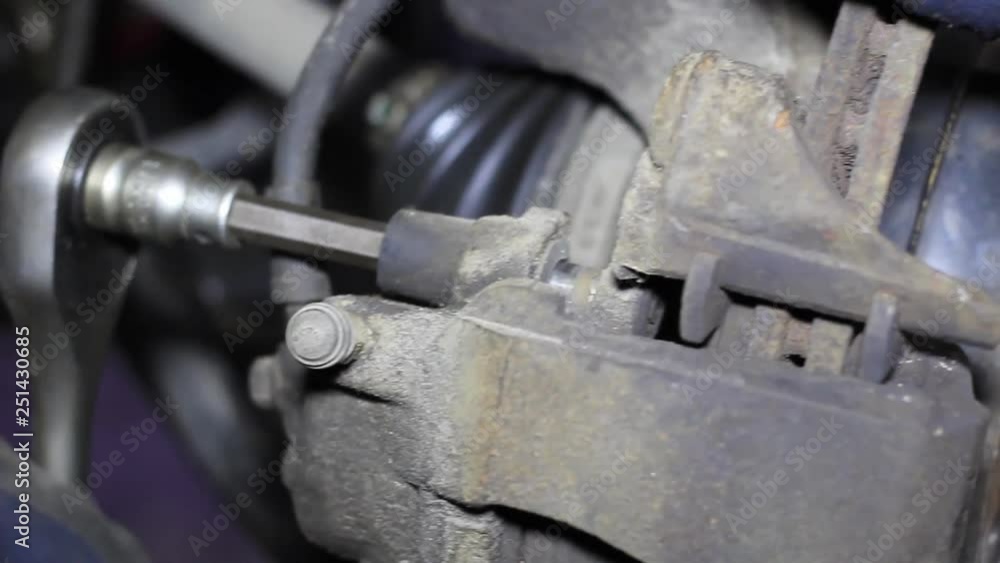 Mechanic for car checking brake system in a car at garage Mechanic for car checking brake system in a car at garage