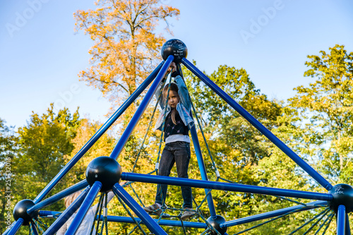 Cute little girl playing on children playground in the park