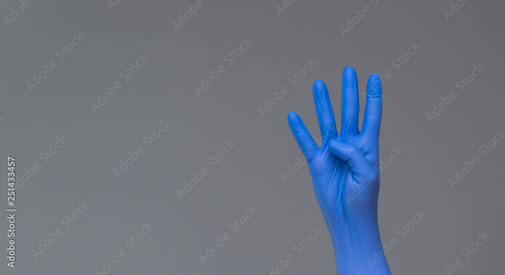 hand in surgical glove shows four fingers on neutral background. Copy space. hand in surgical glove shows four fingers on neutral background. Copy space.