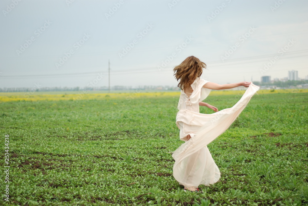 A young tall woman with a long hair at the green field A young tall woman with a long hair at the green field