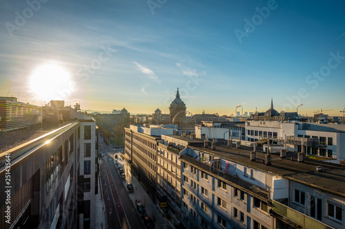 Sunrise over the rooftops in a city © karegg