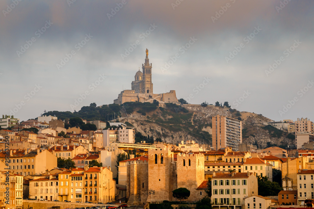 Fototapeta premium Panoramic cityscape of Marseille with the church Notre-Dame de la Garde, landmark of the city, on a hilltop. Marseille, Provence, France. Holidays in France.