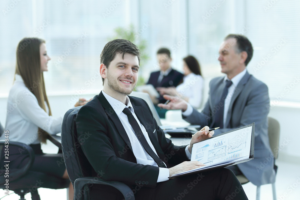 business man at office with his business team working behind business man at office with his business team working behind