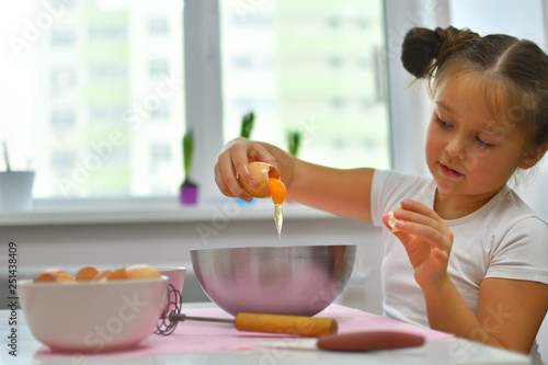 Little girl preparing cookies in kitchen at home. Cooking homemade food.