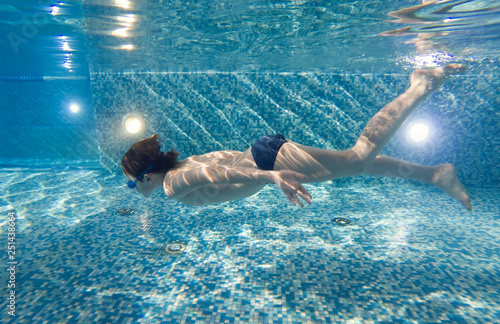 Boy underwater in swimming pool photo