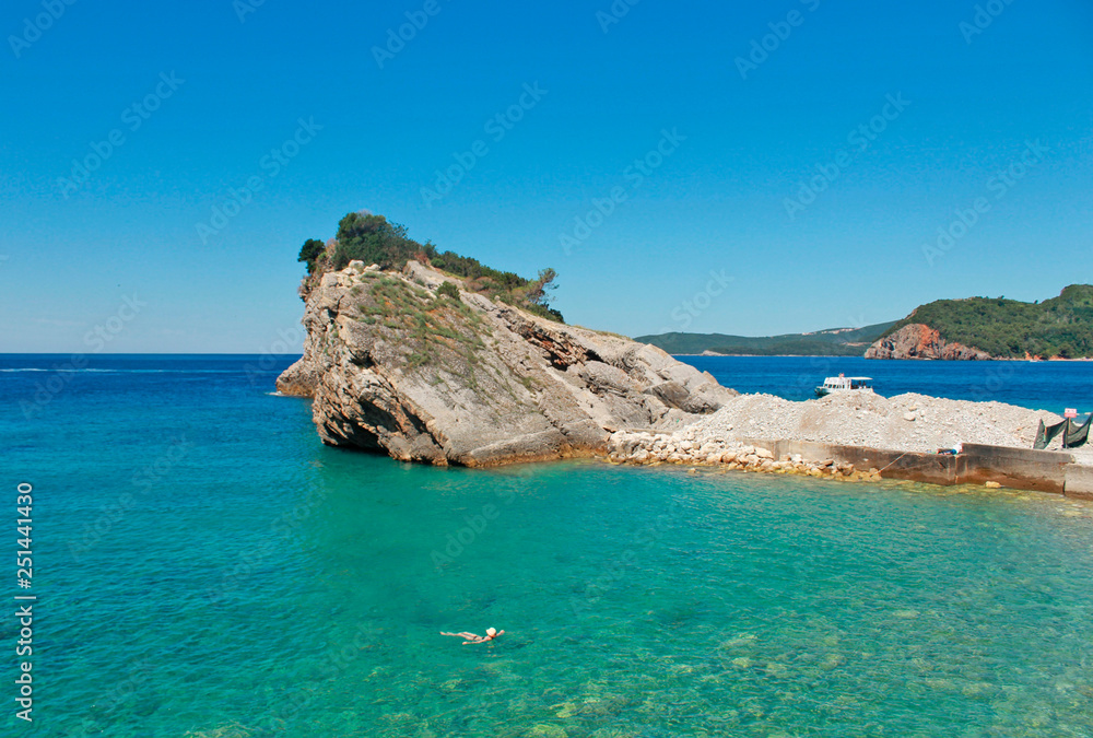 rocks and boat on island of St. Nicholas in Budva, Montenegro. Paradise beach on island in sea. concept of travel