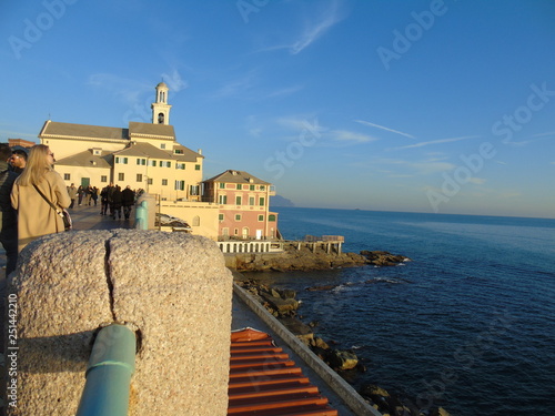 Genova, Italy - 02/14/2019: An amazing caption of the sunset over the sea and the city of Genoa in winter days and great views to the old buildings near the beach coloured by the sun