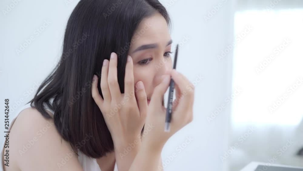 Beauty blogger present beauty cosmetics sitting in front camera for recording video. Happy beautiful young Asian woman use cosmetics review make up tutorial broadcast live video to social network. Beauty blogger present beauty cosmetics sitting in front camera for recording video. Happy beautiful young Asian woman use cosmetics review make up tutorial broadcast live video to social network.