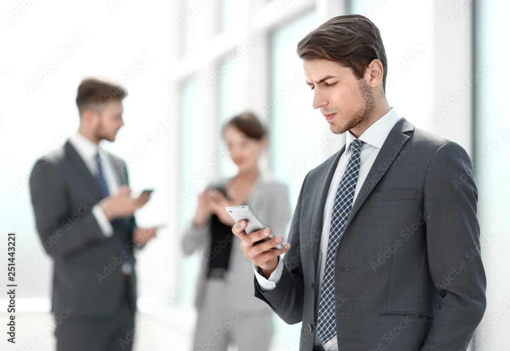 serious businessman reading SMS on his smartphone. serious businessman reading SMS on his smartphone.