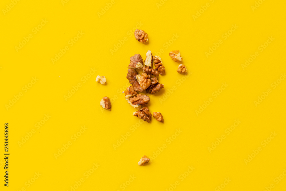 Obraz premium peeled walnut on yellow background isolated text design
