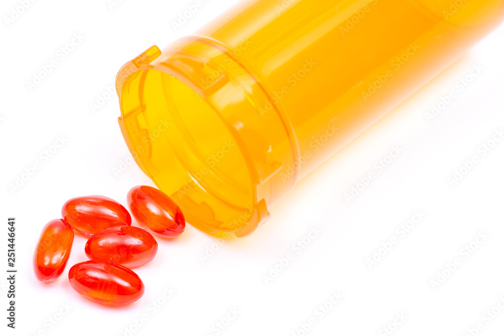 Docusate sodium soft gel capsules next to plastic orange container ...