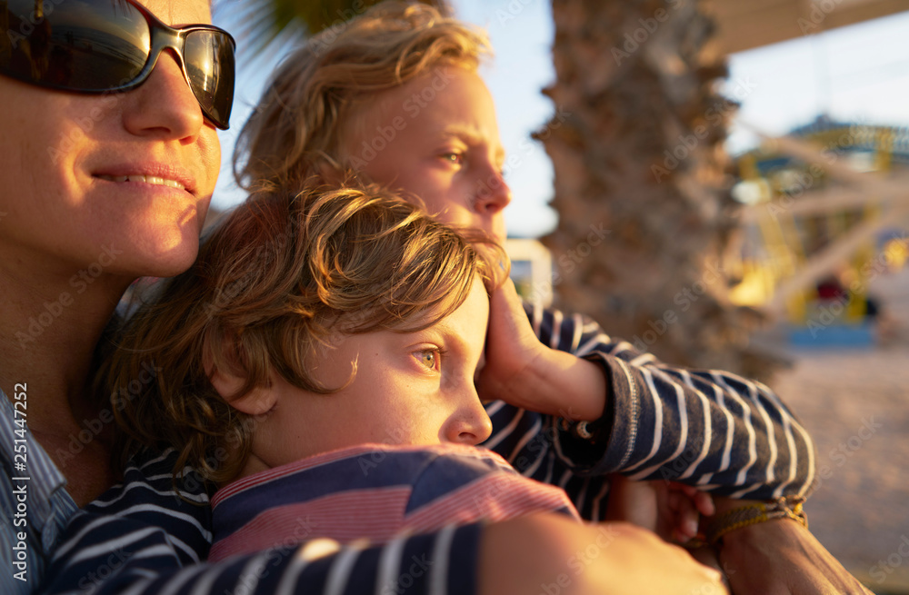 Mother with two sons on the beach at sunset Mother with two sons on the beach at sunset