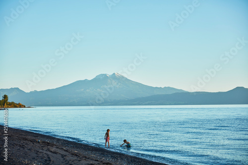 Chile, Lago Llanquihue, Calbuco volcano, two boys playing in water