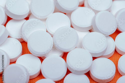 Non-steroidal anti-inflammatory drugs. Acetaminophen white tablets on orange background.  photo