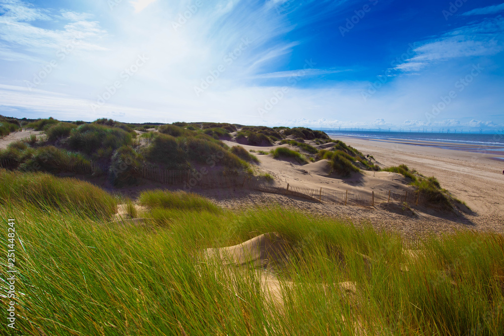 Coastal sand dunes with a blue sky