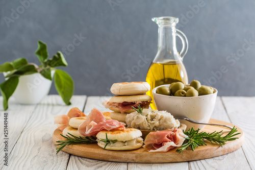Crescentina modenese or tigelle ,  round breads from the Apennines, Modena area of Emilia-Romagna, Northern Italy, with cunza, a spread made from pork lard and flavoured with garlic and rosemary photo