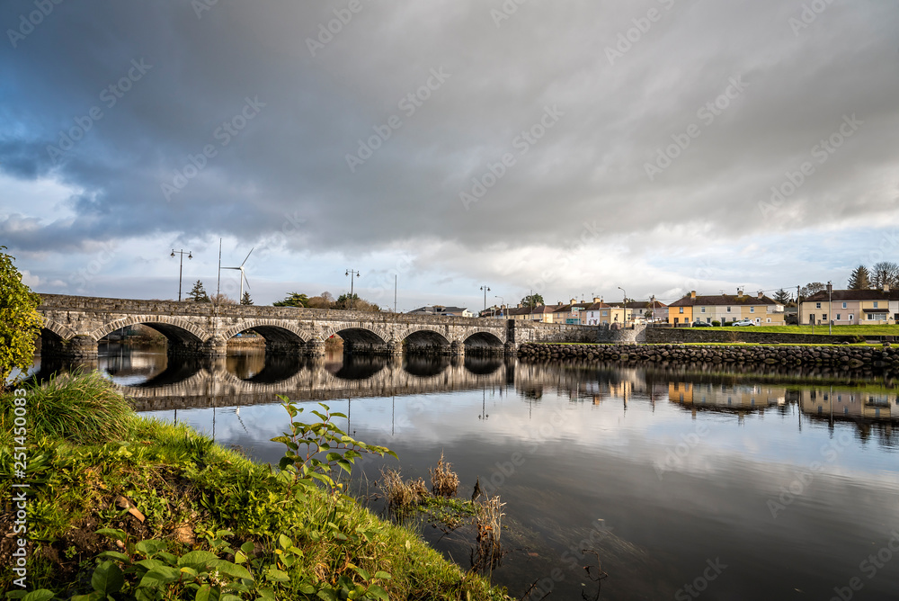 Arch bridge over river against cloudy sky in city Arch bridge over river against cloudy sky in city