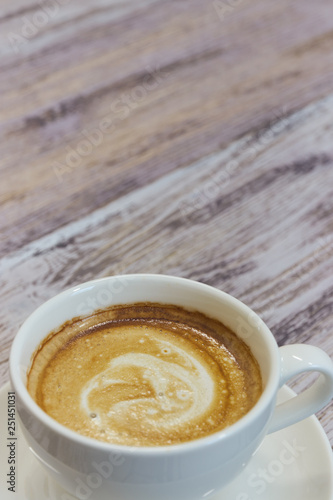 white Cup of coffee on a wooden table close-up. black coffee with milk. wooden table with a fragrant drink. vertical view. copy space.