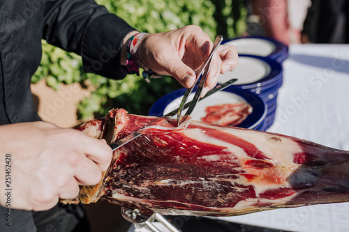 man cutting ham