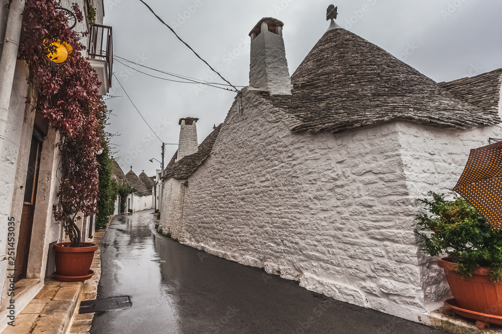 View of Alberobello street with typical Trulli in a rainy day, Puglia, Italy