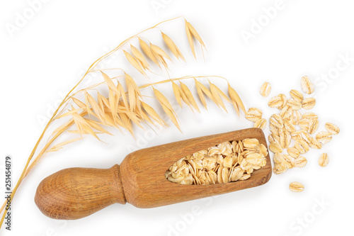 oat spike with oat flakes in wooden scoop isolated on white background. Top view. Flat lay