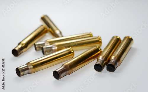 A rifle bullet, empty shells on white background.