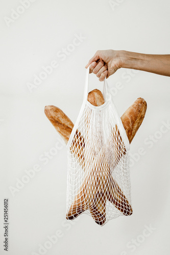 woman holding a tote bag with baguettes
