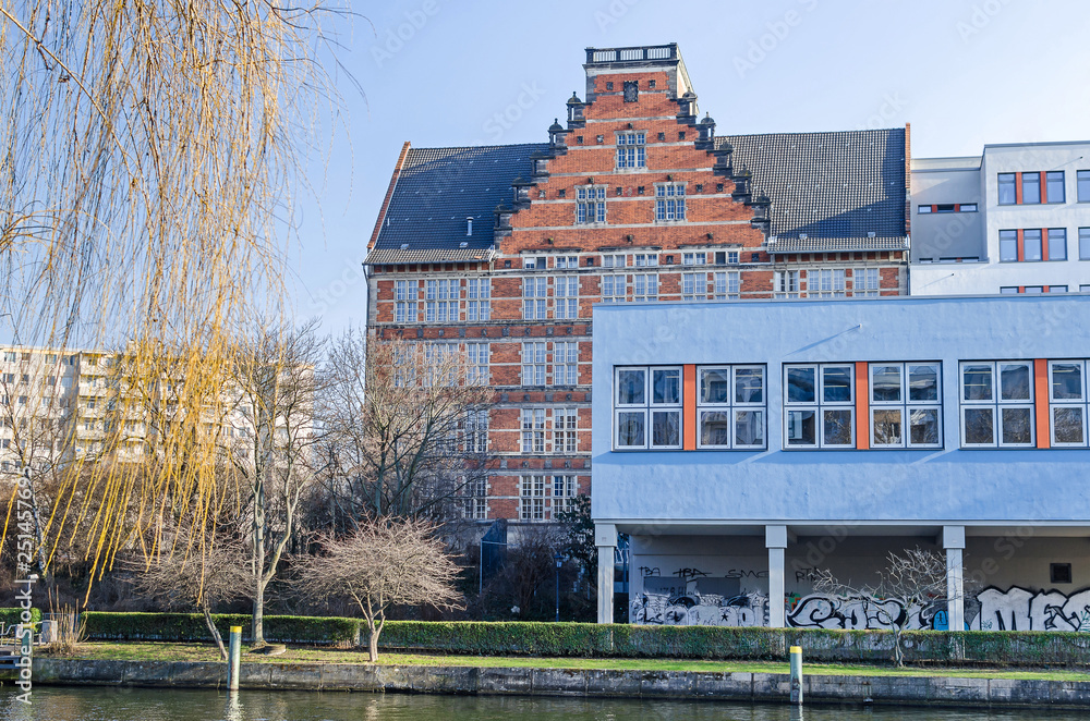 Obraz premium Spree river embankment Holsteiner Ufer with buildings of a Gymnasium school in Berlin, Germany