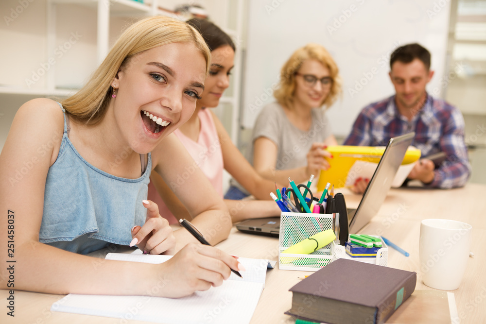 Side view of much laughing girl, sitting at table. Side view of much laughing girl, sitting at table.