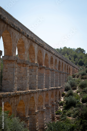 Acueducto de Les Ferres en tarragona, España con montaña al fondo y el cielo claro