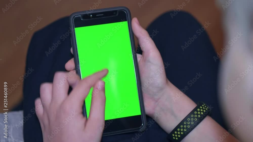 The boy looks into the smartphone with green chroma screen The boy looks into the smartphone with green chroma screen
