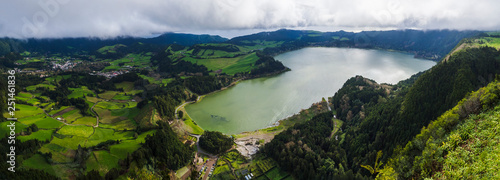Panoramic landscape with aerial view on beautiful blue green crater lake Lagoa das Furnas and village Furnas with vulcanic thermal area. Sao Miguel, Azores, Portugal. Countryside landscape with green